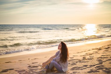 Esmer kız deniz günbatımının arka planında