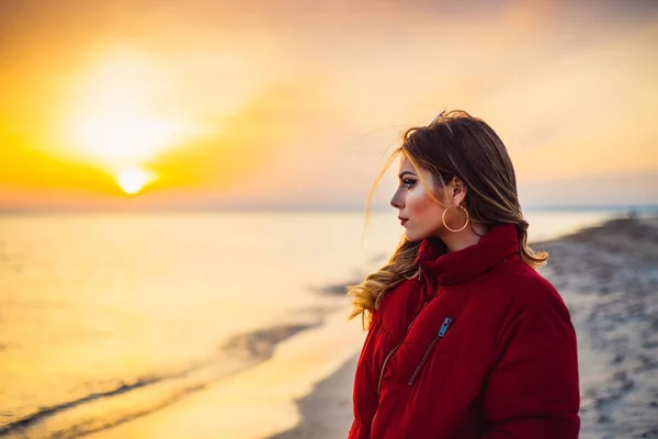 Blondes Mädchen auf dem Hintergrund des Meeres und Sonnenuntergangs — Stockfoto