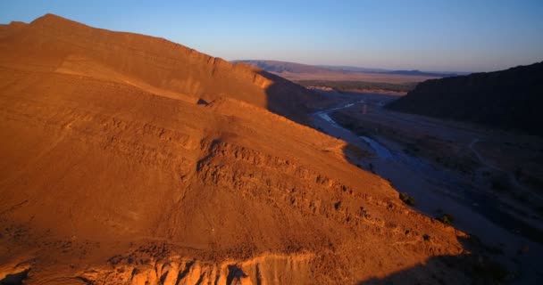 Aérea, Volando sobre Palm Oasis a lo largo de las montañas en Tissint, Marruecos — Vídeos de Stock