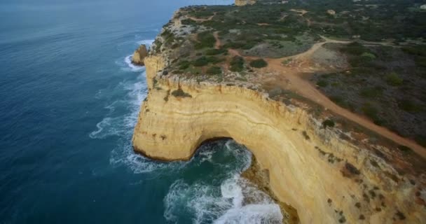 Aérea, Volando a lo largo de la empinada línea del acantilado en Ferragudo, Portugal — Vídeos de Stock