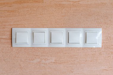 Duvardaki beyaz ışık düğmeleri. Kapalı mekan fotoğrafı. Elektrik.