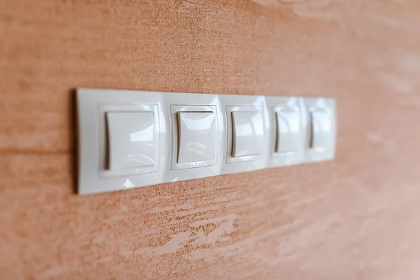 White light switches on a wall. Indoor photo.  Electricity