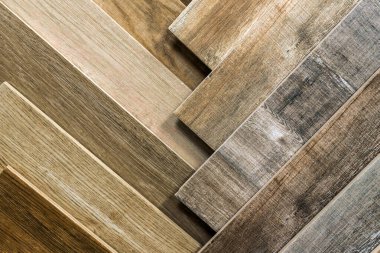 Variety of wooden like tiles. Samples of fake wood tiles for flooring. Assortment of floor laminate / tiles in an interior shop. clipart