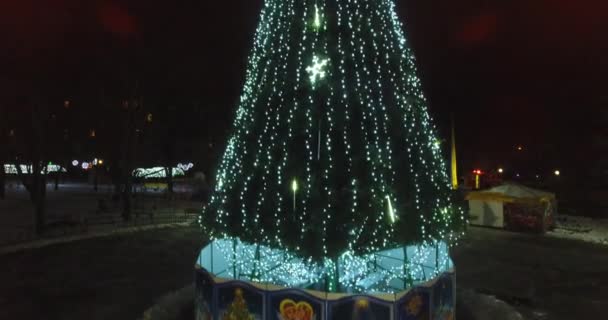 Havadan görünümü akıllı Noel ağacı kare gece şehir üzerinde duruyor — Stok video