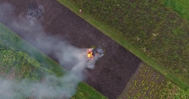 농부 분야에서 큰 모닥불 연기 최대 상승 저녁 하늘의 공중 장면 — 비디오
