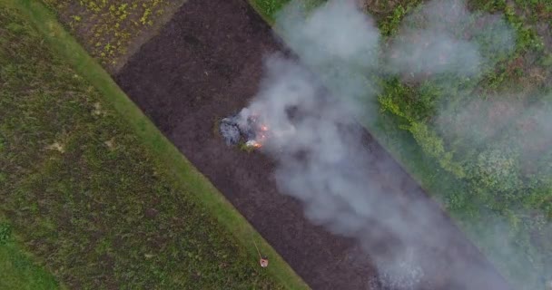 Filmagem aérea de grande fumaça de fogueira subindo até o céu à noite em campos de agricultores — Vídeo de Stock