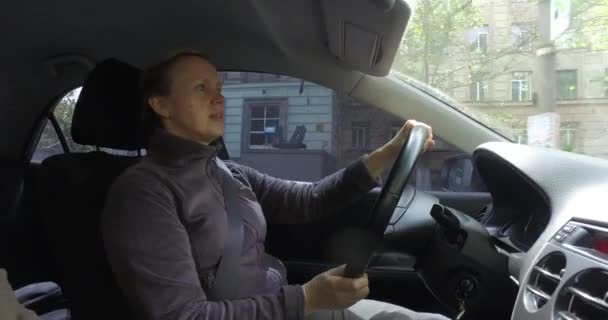 Femme mûre conducteur assis au volant de la voiture et regardant attentivement la route — Video