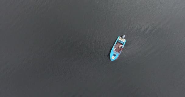 Вид сверху лодки с пожарным, который ловит рыбу на удочку — стоковое видео