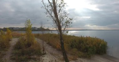 Hareket dronun tükürmek kum ve fırtına gökyüzü nehire karşı yeşil ağaç çevresinde