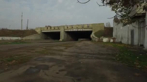 Movimiento de un ciclista con una cámara bajo un puente ferroviario de hormigón — Vídeo de stock