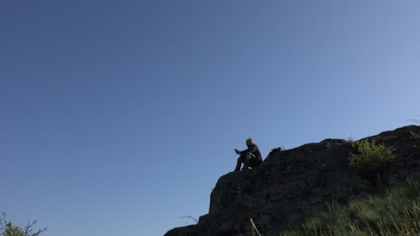 Toeristische man gelukkig praten over telefoon aan rand van de klif in diepe canyon — Stockvideo