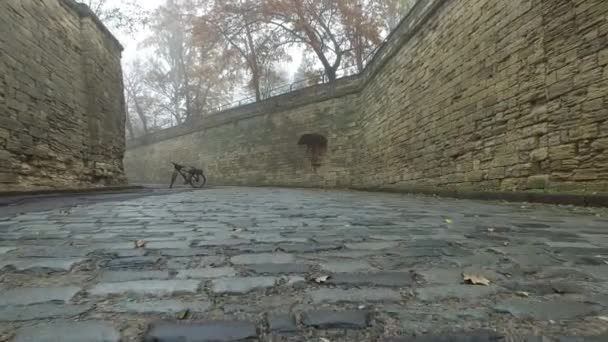 シェルレンガで作られた壁の間で石の古い舗装上の動き 光霧の秋の街 — ストック動画
