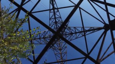 Elektrik direğinde paslı demir kirişler, üstten kablolarla tepe manzarası