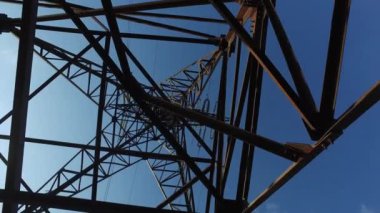 Elektrik direğinde paslı demir kirişler, üstten kablolarla tepe manzarası