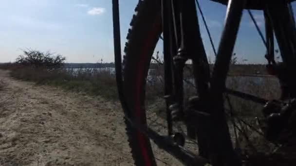 Vista Través Rueda Trasera Bicicleta Camino Tierra Retroceso Río Verano — Vídeo de stock