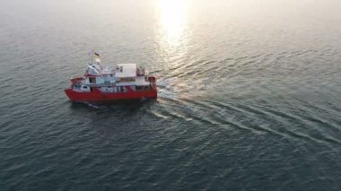 İHA 'dan hava görüntüsü. Kızıl katamaran, insanlı okyanus keşif gemisi, açık deniz / okyanus arasında tam bir salınımda.