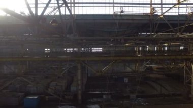 Eski terk edilmiş bir fabrikanın tepesinde demir paslı bir merdivende hareket var.