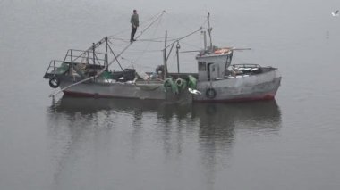 Mykolaiv, Ukraine - Oct 21 2019: Top view of a small old, metal fishing ship that catches fish with fishing nets in old trawling