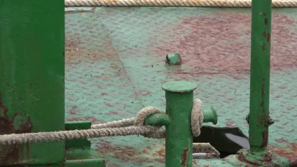 Borne d'amarrage avec corde de chanvre sur un vieux ponton en métal rouillé portant une chargeuse jaune 