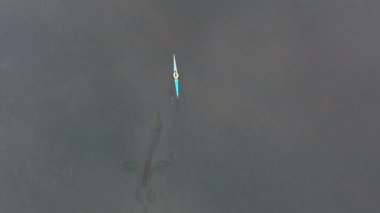 Hava görüntüsü. Tarih öncesi çağın canavarı Ejderha su altında kano Ness Canavarı 'nın yanında yüzer.