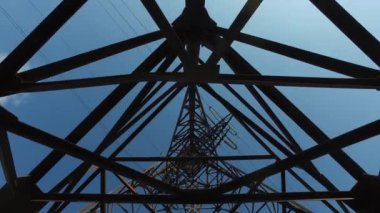 Elektrikli direğin paslı demir kirişlerinden oluşan düz çizgiler, aşağıdan yukarıya doğru.