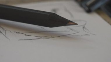 Makro manzara. Grafik Kalemi belirsiz bir şeklin hangi kalem çizimi üzerine beyaz kağıt yaprağının üzerinde yatar