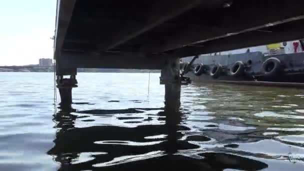 从河港装卸机桥下水面看船舶上的汽车轮胎 如系泊用挡泥板 — 图库视频影像