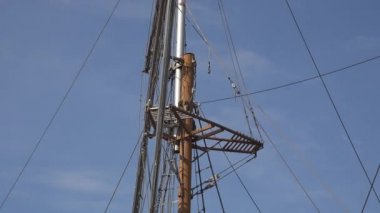 Tahta yelkenli direği. Üstünde izleme platformu, ip merdivenleri ve ip ekipmanları var.