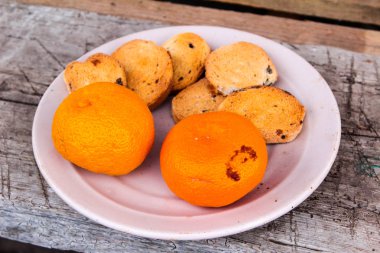 Ekmek kırıntıları ve mandalinalı bir tabak fro kürsünün üstünde.