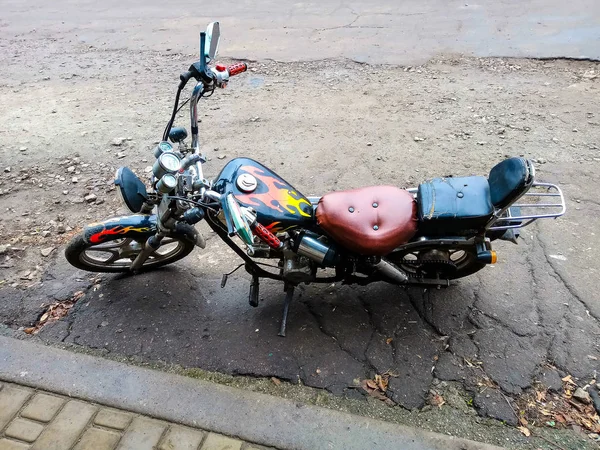 Una motocicleta montada con sus propias manos está de pie cerca de un su — Foto de Stock