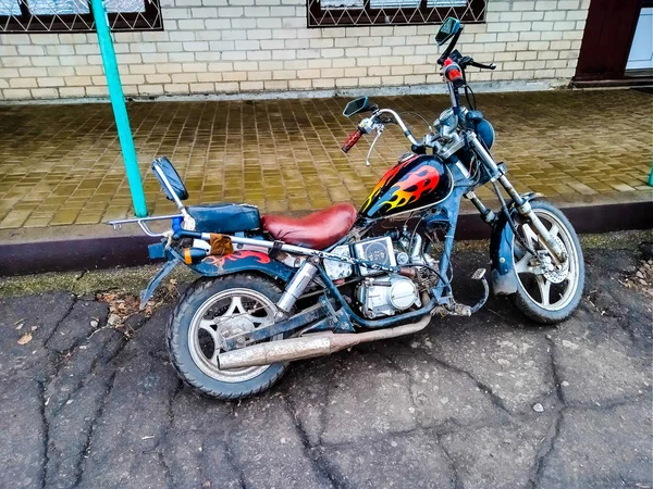 Una motocicleta montada con sus propias manos está de pie cerca de un su — Foto de Stock