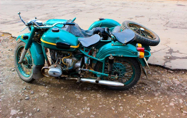 An old Soviet motorcycle with a sidecar stands on the sidelines — Stock Photo, Image