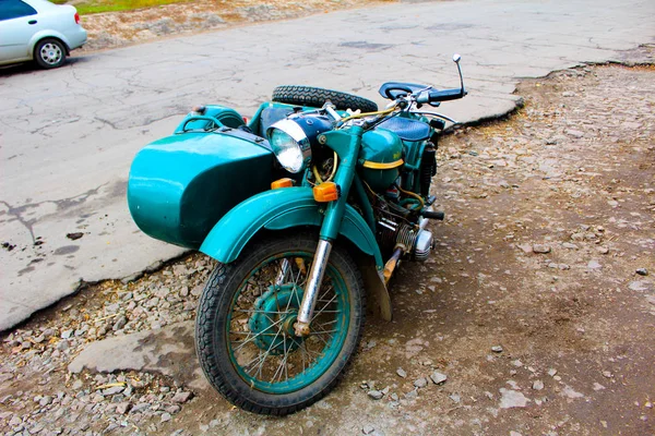 Uma velha moto soviética com um sidecar fica à margem — Fotografia de Stock