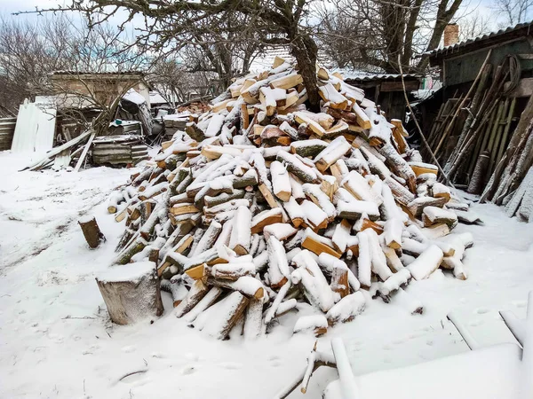 Een stapel gehakte boomstammen bedekt met sneeuw — Stockfoto