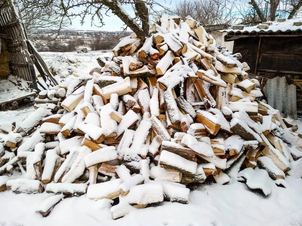 Setumpuk kayu yang terpotong tercakup dalam salju — Stok Foto