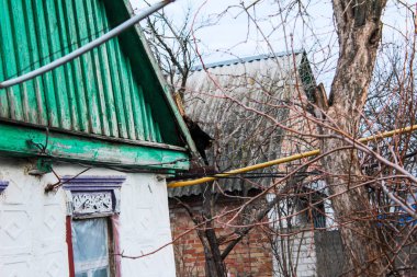 Kiremit çatıda yürüyen bir kedi bacadan duman çıkarıyor.