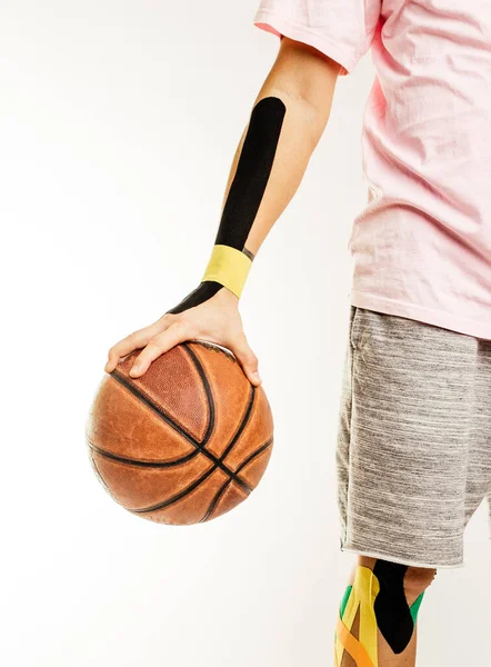 怪我をしたバスケットボール選手はボール 腕と足のKinesotapeに立っている — ストック写真