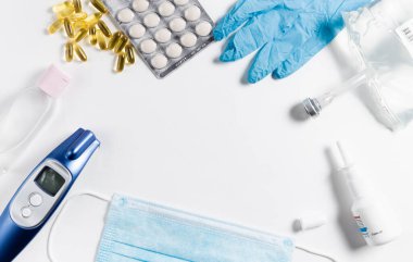 Tıbbi maske, elektronik termometre, haplar, eldivenler, beyaz izole arka planda antiseptik tuz çözeltisi, üst görüş. Sağlık konsepti. Virüslere karşı koruma, koronavirüsler, grip, soğuk algınlığı, hastalıklar. Alerji Sezonu Coronavirüs veya Covid-19.