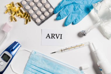 Tıbbi maske, elektronik termometre, haplar, eldivenler, beyaz izole arka planda antiseptik tuz çözeltisi, üst görüş. Sağlık konsepti. Virüslere karşı koruma, koronavirüsler, grip, soğuk algınlığı, hastalıklar. Alerji Sezonu Coronavirüs veya Covid-19.