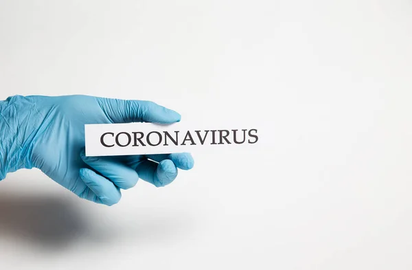 Une Main Dans Gant Médical Tient Inscription Coronavirus Sur Fond Photo De Stock