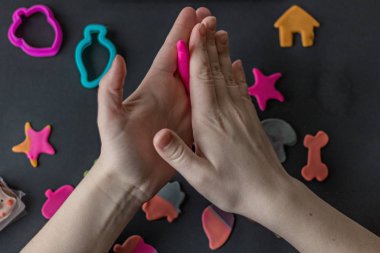 Pişirmeyi süslemek için ellerinle ve kurabiye kesicilerinle yenilebilir badem ezmesi figürleri yapıyorsun. Fotoğraftaki kızın elleri hazırlanma aşamasındaydı. Hazır ve paketlenmiş zencefilli kurabiyeler masada..