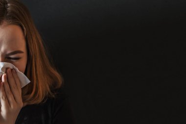 Burnu buruşuk, burnu kırışık, ateşi çıkmış, nezle olmuş, doku hapşırması geçirmiş alerji belirtileri gösteren hasta, evde öksüren, grip konsepti olan genç bir kadın. Viral enfeksiyon. Covid-2019.