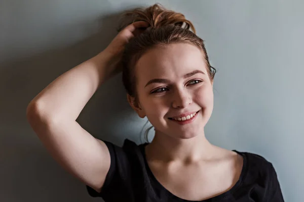 Uma Jovem Garota Sorrindo Ajusta Seu Cabelo Com Mão Contra — Fotografia de Stock