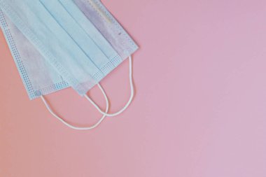 Pembe arka planda mavi cerrahi maskeler. Covid-19 - Wuhan Yeni Coronavirus pnömonisi. Nefes almak için koruyucu maske. Koronavirüs salgını enfeksiyonu.