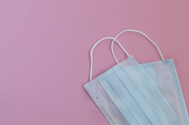 Pembe arka planda mavi cerrahi maskeler. Covid-19 - Wuhan Yeni Coronavirus pnömonisi. Nefes almak için koruyucu maske. Koronavirüs salgını enfeksiyonu.