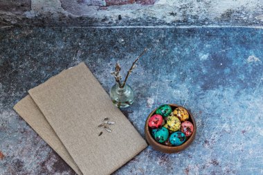 Mutlu Paskalyalar, bıldırcın renkli benekli yumurtalar keten bir havluyla ahşap bir kasede ve söğüt dalları küçük bir vazoda, bahar Ortodoks ve Katolik bayramının sembolü..