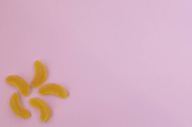 Pembe arka planda dilimlenmiş meyve reçeli..