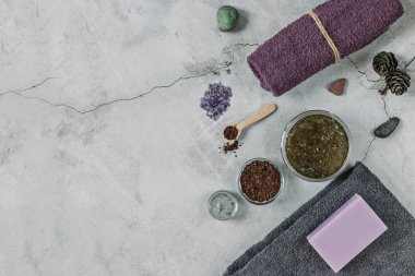 Gri arka planda Spa kişisel bakım için aksesuarlar bulunmaktadır: vücut fırçası, öğütülmüş kahve, lavanta sabunu, yüz maskesi kremi, banyo tuzu, yüz ve vücut için Terry havlusu.