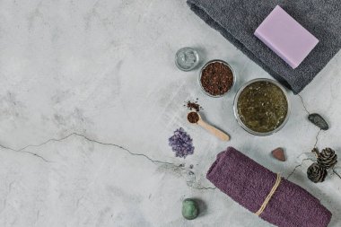 Gri arka planda Spa kişisel bakım için aksesuarlar bulunmaktadır: vücut fırçası, öğütülmüş kahve, lavanta sabunu, yüz maskesi kremi, banyo tuzu, yüz ve vücut için Terry havlusu.
