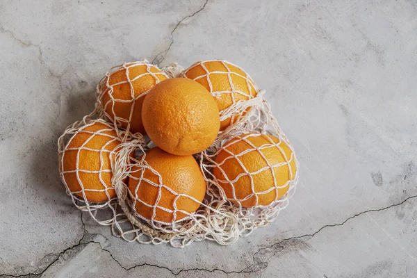 Oranges Eco Netted Gray Bag Gray Background Environmental Care Waste — Stock Photo, Image